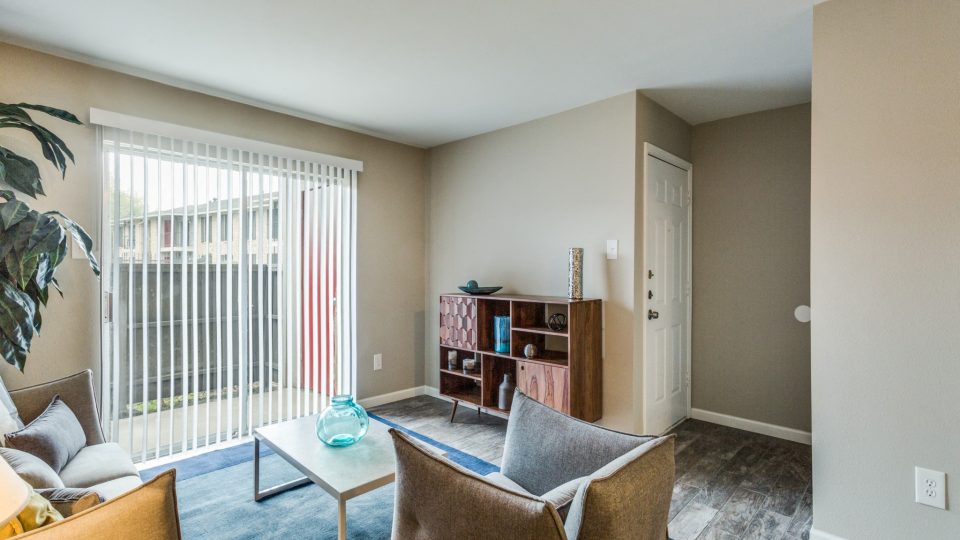 Bright staged living room with large window at Clear Creek Landing in Houston, TX