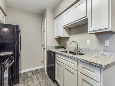 Kitchen with granite counters and generous cabinetry at Clear Creek Landing in Houston, TX