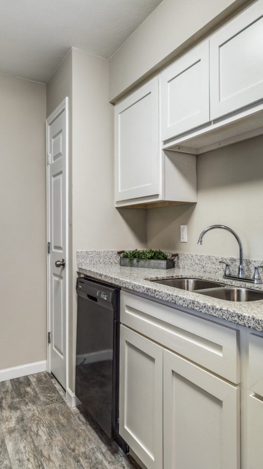 Kitchen with granite counters and generous cabinetry at Clear Creek Landing in Houston, TX