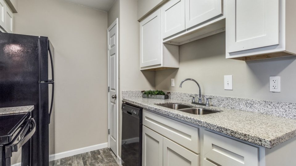Kitchen with granite counters and generous cabinetry at Clear Creek Landing in Houston, TX