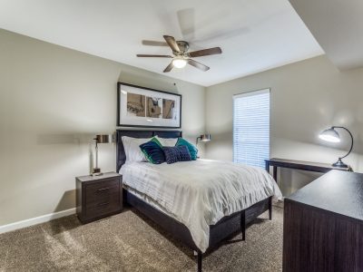 Comfortable carpeted bedroom with ceiling fan and natural light at Clear Creek Landing in Houston, TX