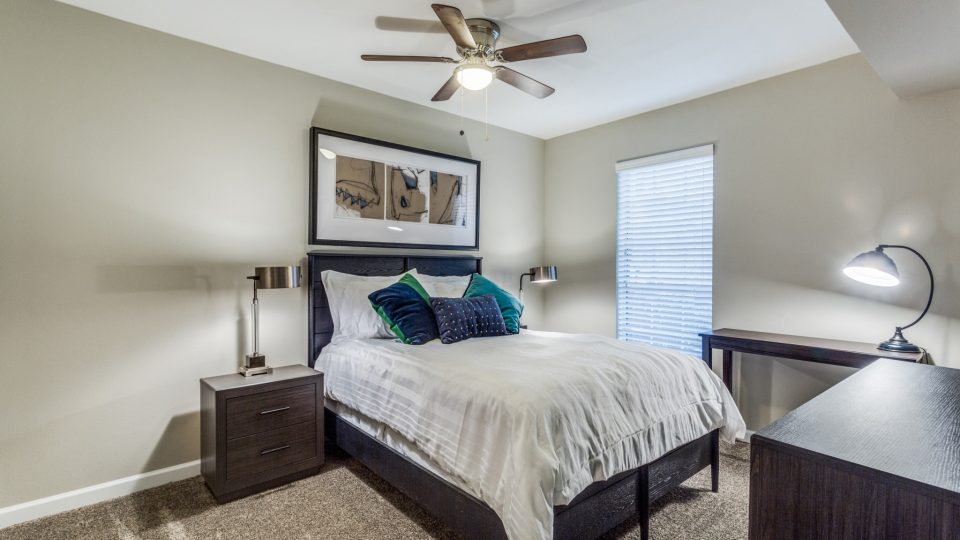 Comfortable carpeted bedroom with ceiling fan and natural light at Clear Creek Landing in Houston, TX