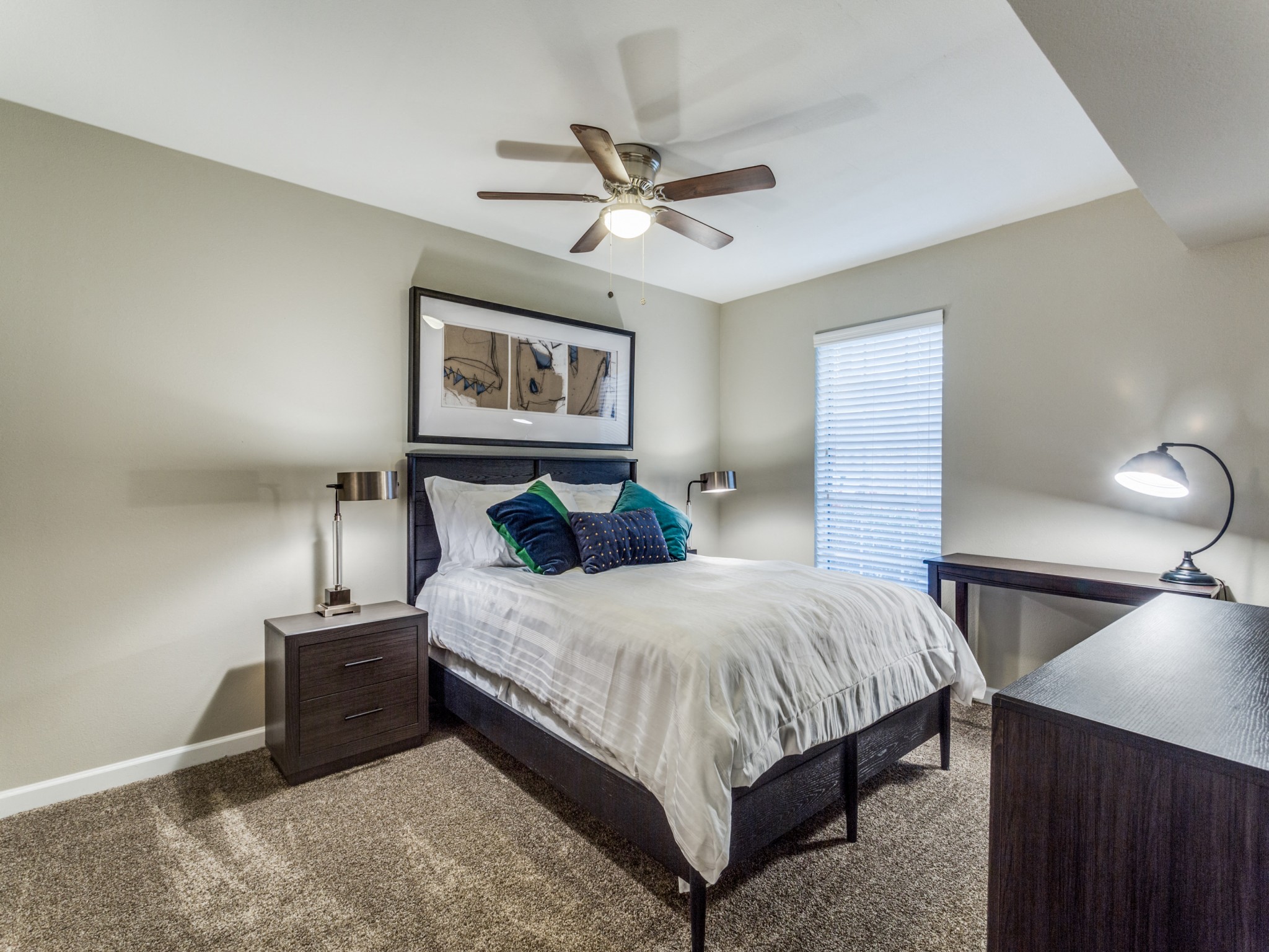 Comfortable carpeted bedroom with ceiling fan and natural light at Clear Creek Landing in Houston, TX