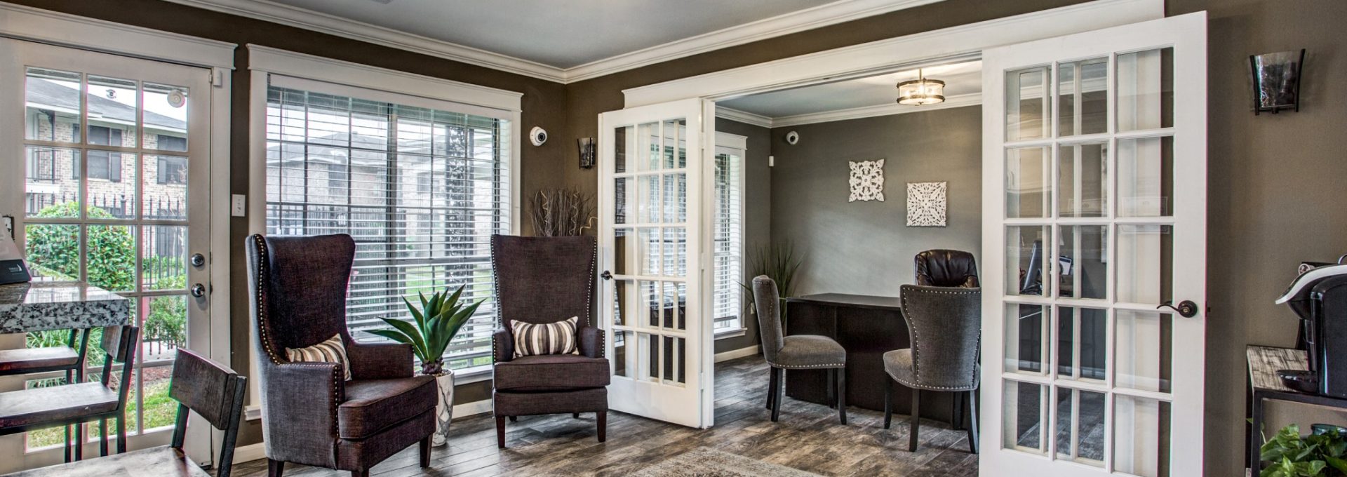 Spacious living room with French doors and wood-style flooring at Clear Creek Landing in Houston, TX