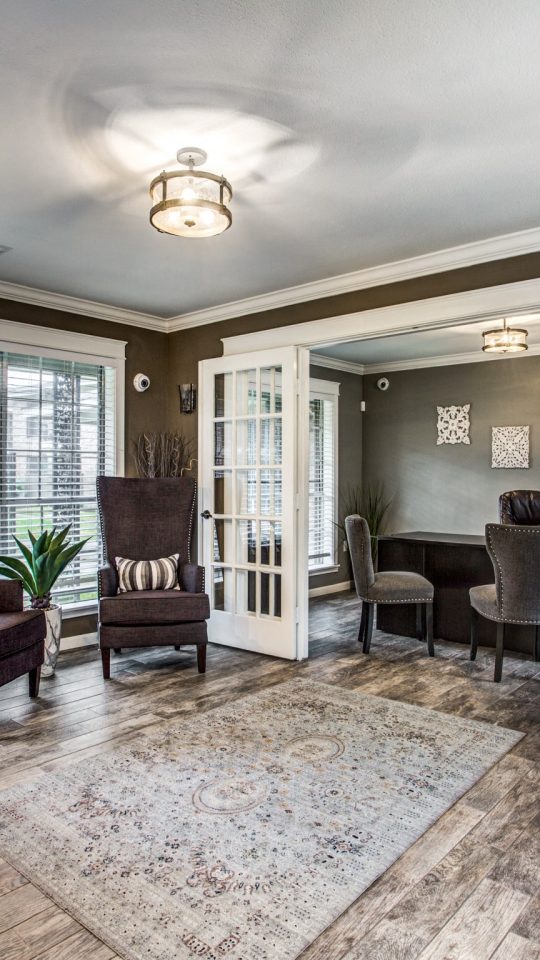 Spacious living room with French doors and wood-style flooring at Clear Creek Landing in Houston, TX