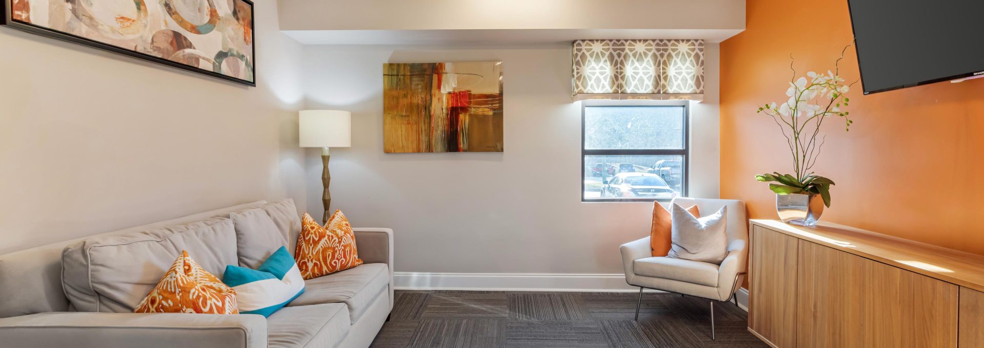a living room with orange walls and a flat screen tv at The  Park at Fountain City