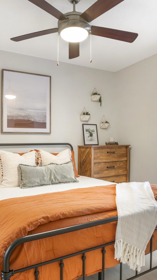 a bedroom with a bed, dresser and ceiling fan at The  Monte