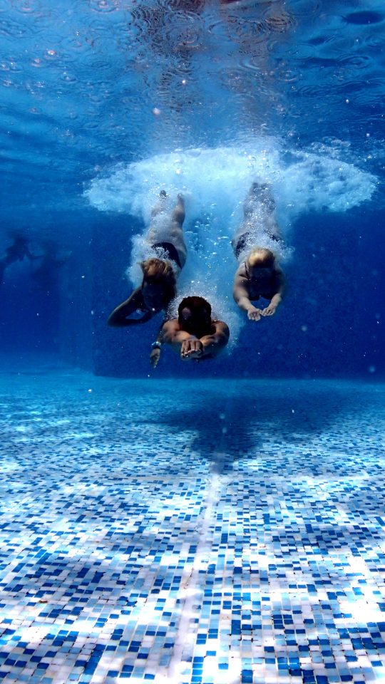 three person diving on water