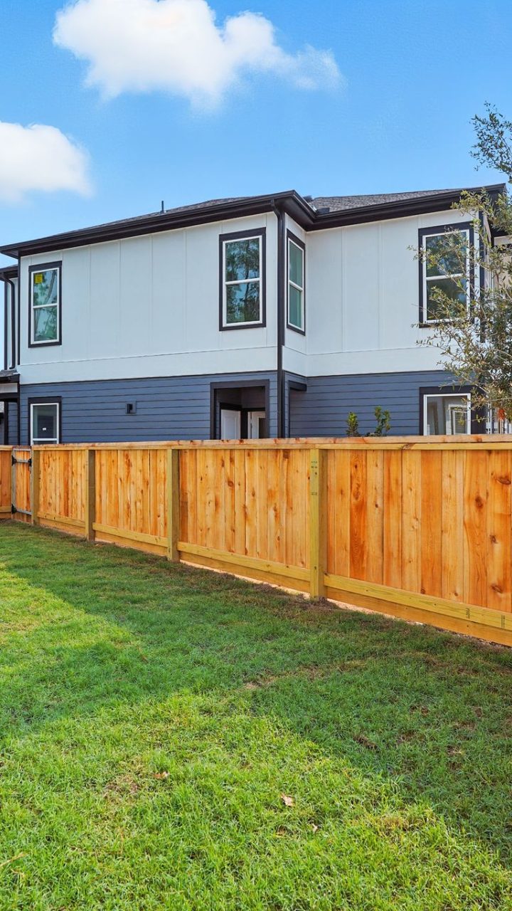 3-Bedroom Homes for Rent in Conroe, TX - Soltera Rolling Pines - Yard With Wood Privacy Fence, Green Lawn, And Neighborhood Home Views Under Bright Blue Sky.