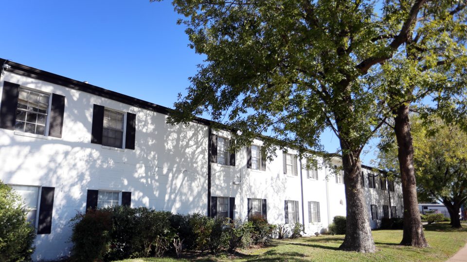 the exterior of an apartment building with trees and bushes at The Vista Villa Apartments