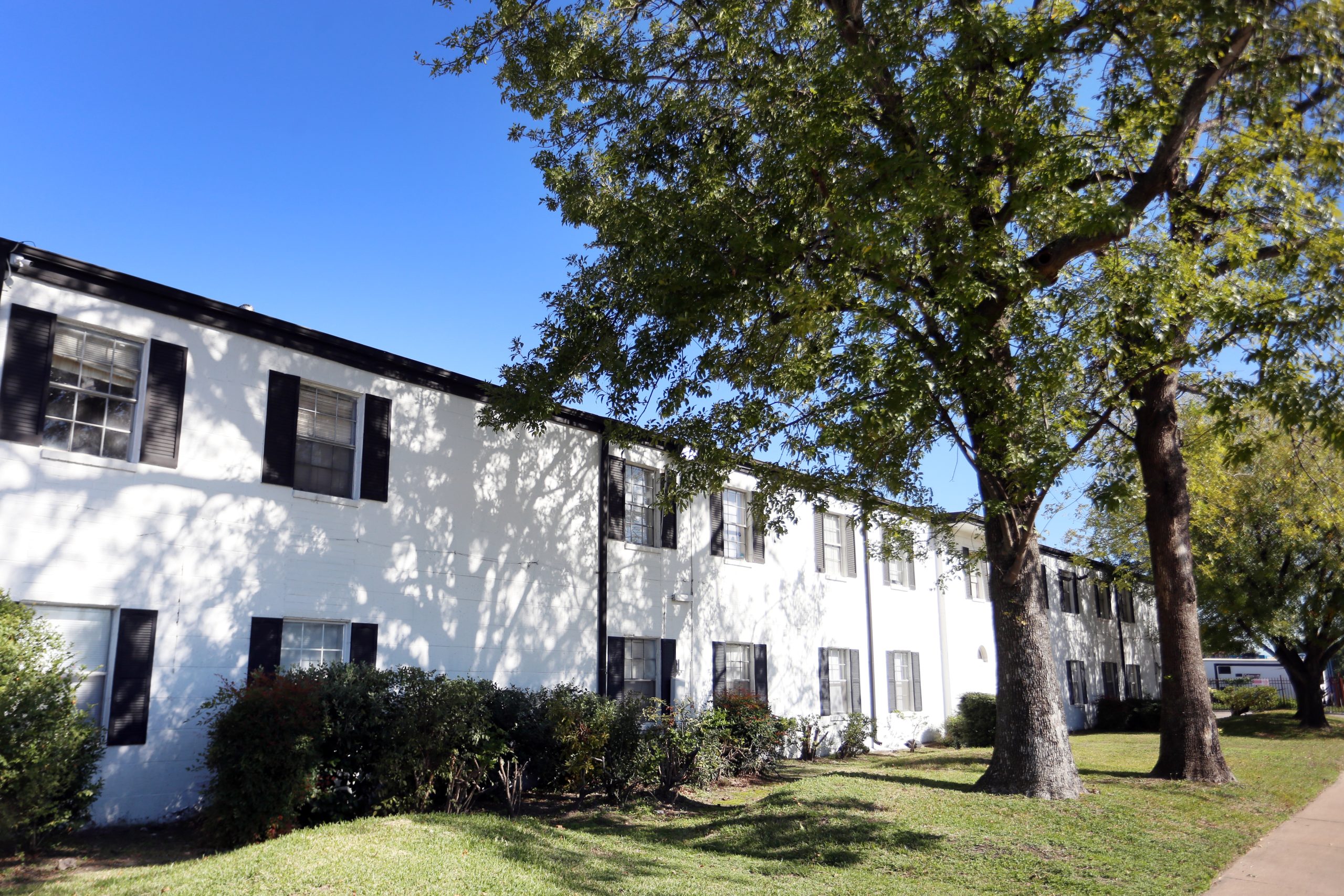 the exterior of an apartment building with trees and bushes at The Vista Villa Apartments