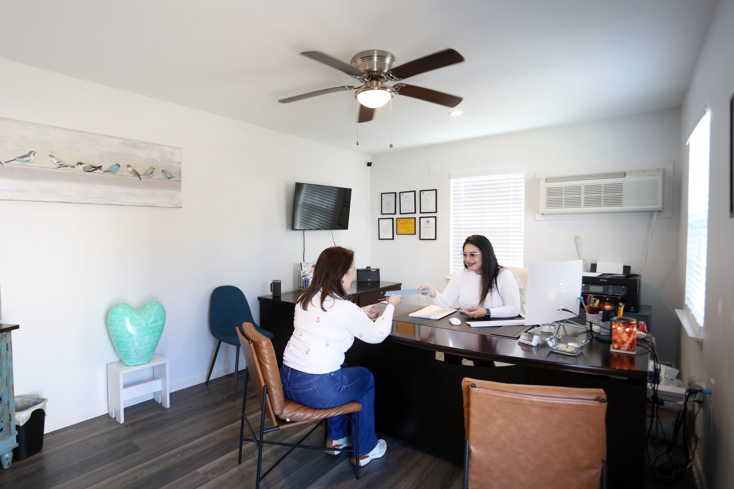 two women sitting at a desk in an office at The Vista Villa Apartments