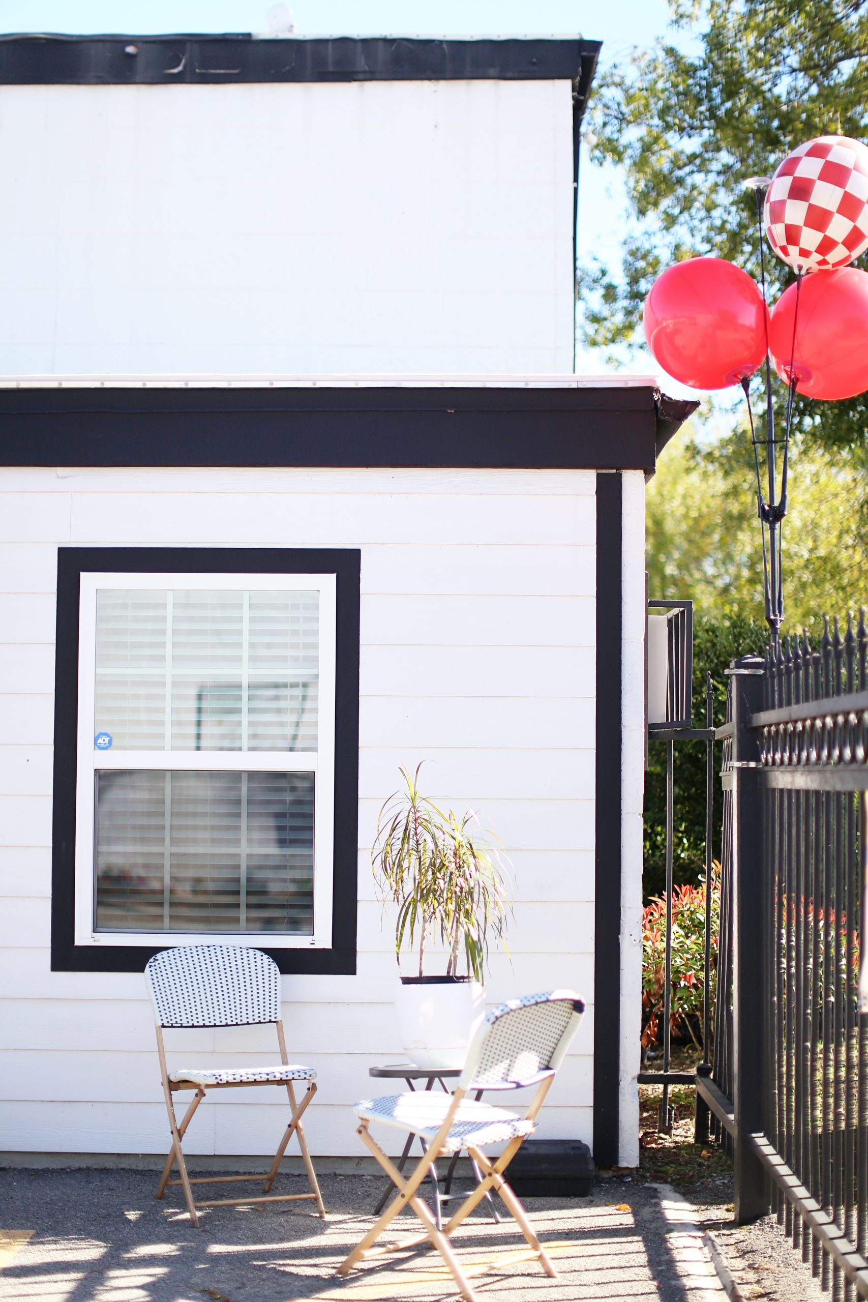 a small white house with red and white balloons at The Vista Villa Apartments