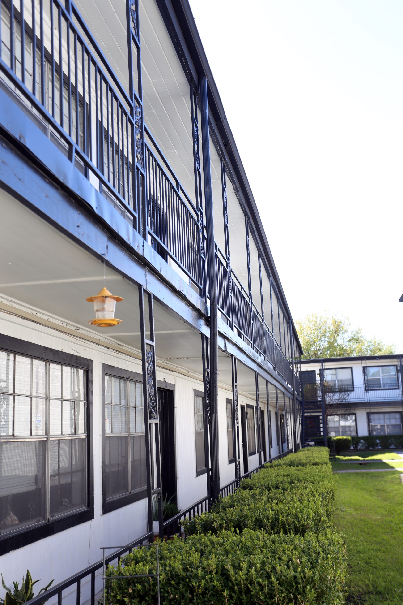 the outside of a building with balconies and bushes at The Vista Villa Apartments