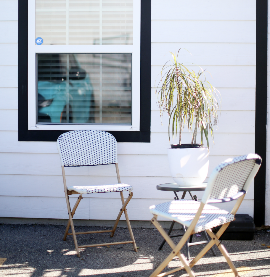 two chairs and a potted plant outside a house at The Vista Villa Apartments
