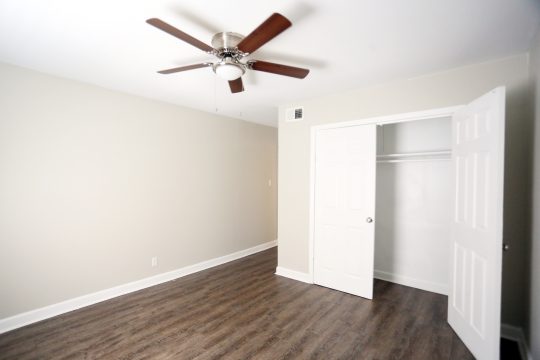 empty room with ceiling fan and hardwood floors at The Vista Villa Apartments