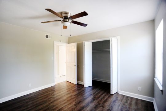 empty room with ceiling fan and hardwood floors at The Vista Villa Apartments