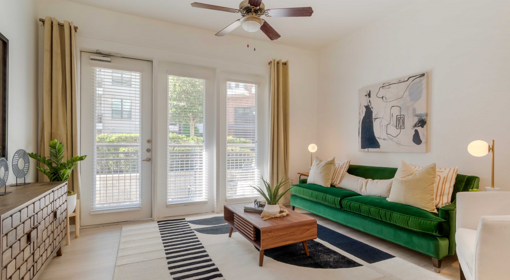 a living room with a green couch and a large window at The Allure