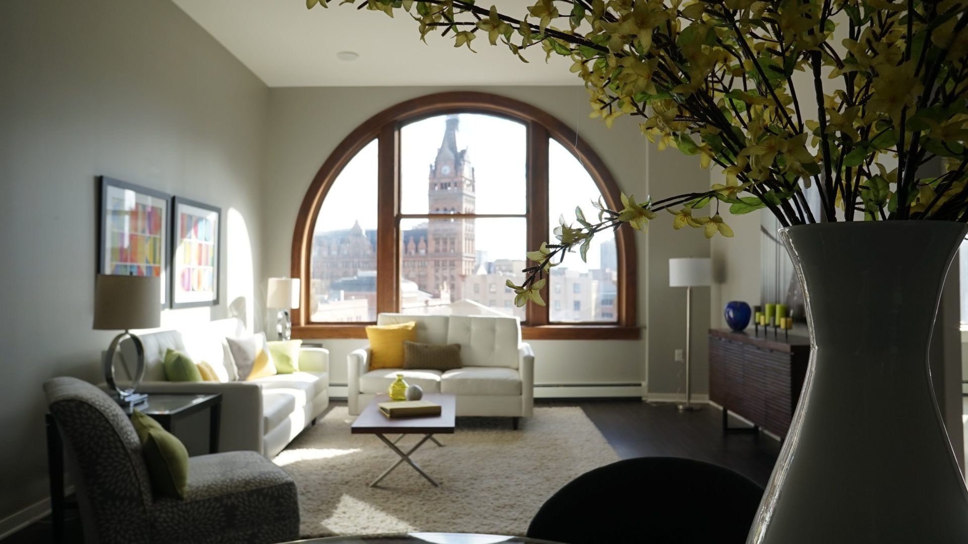 a living room with a large window and a clock at The Germania Apartments