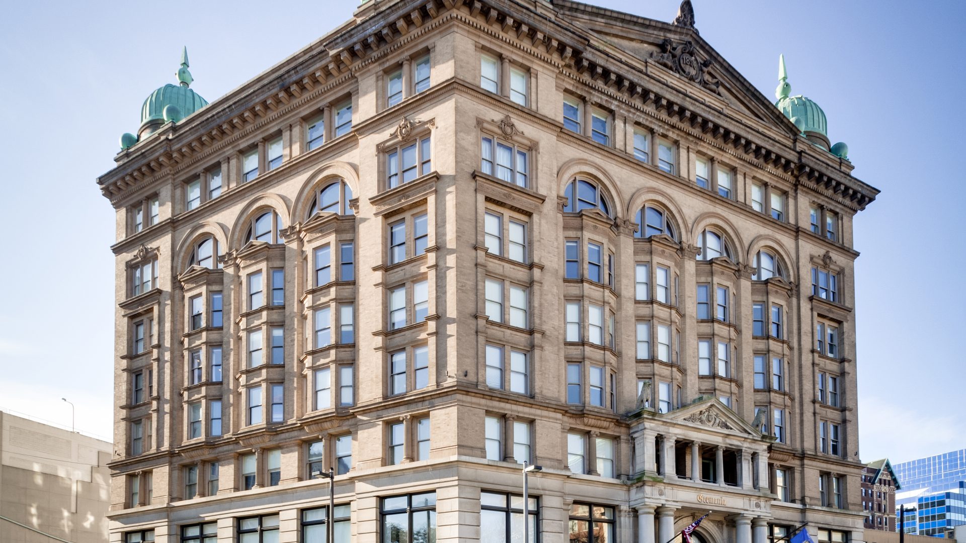a large building with a clock on top at The Germania Apartments