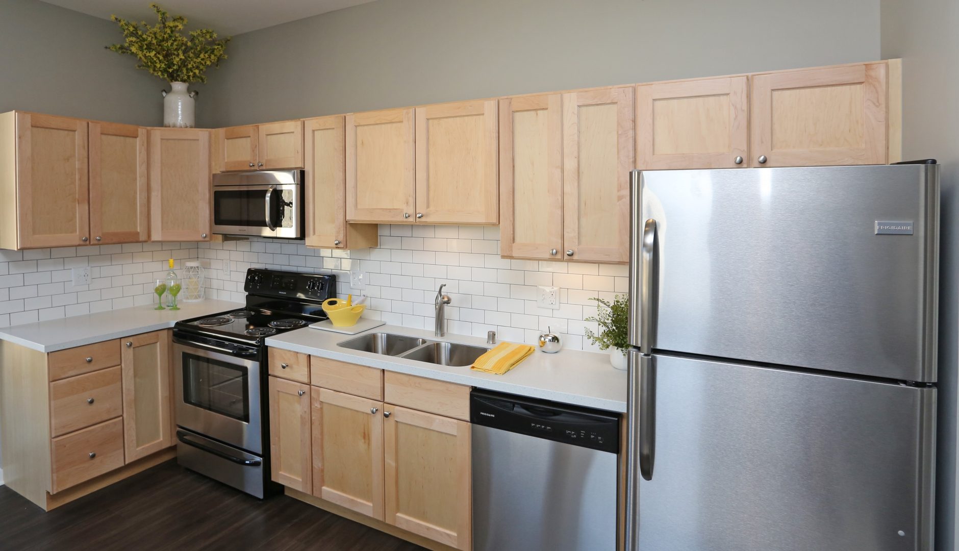 a kitchen with stainless steel appliances and wood cabinets at The Germania Apartments