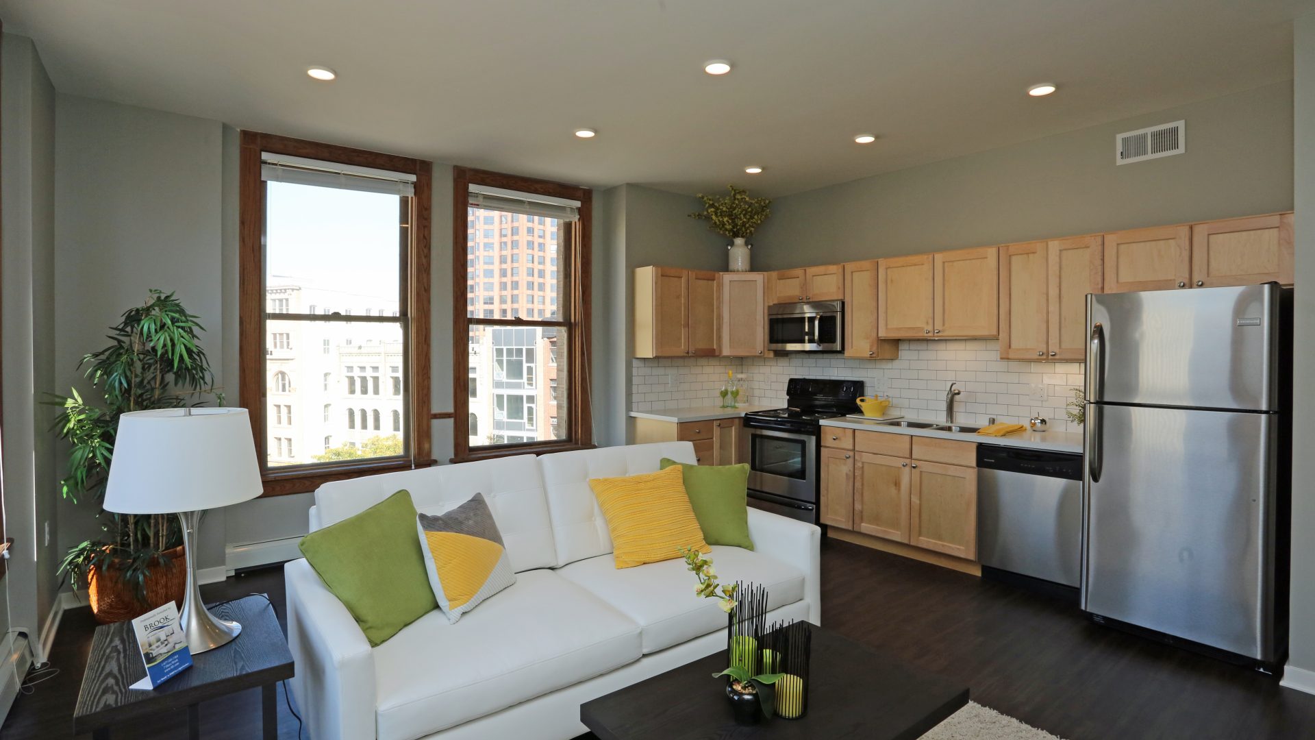 a clean and well - furnished living room with a couch and a kitchen at The Germania Apartments