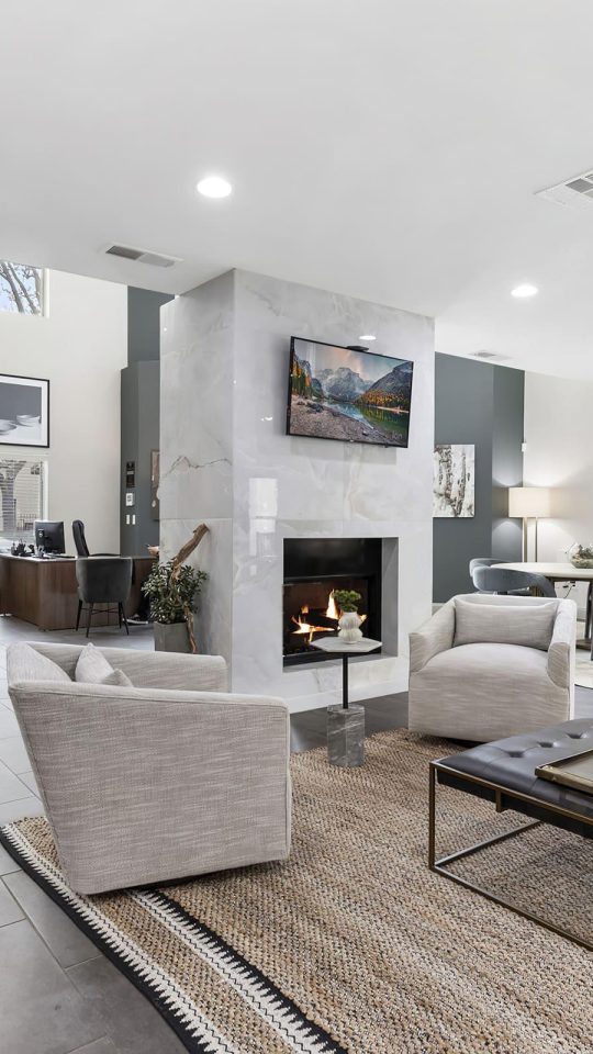 the living room has a fireplace and a large television at The  Adelene