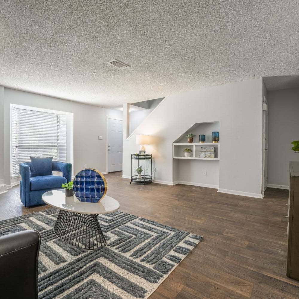 a living room with blue furniture and a staircase at The Lakebridge Townhomes