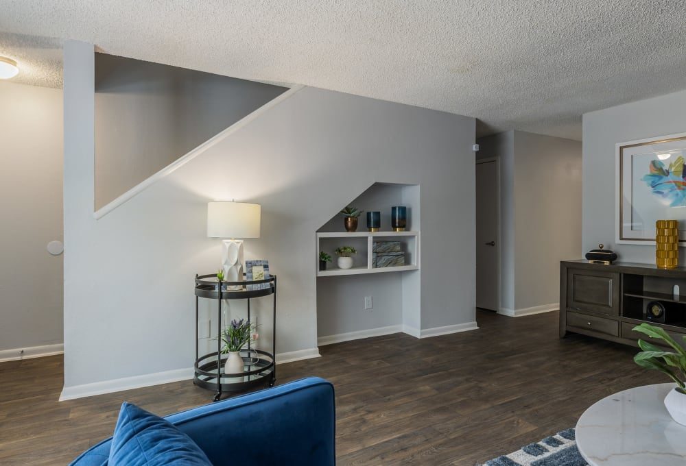 a living room with blue furniture and stairs at The Lakebridge Townhomes
