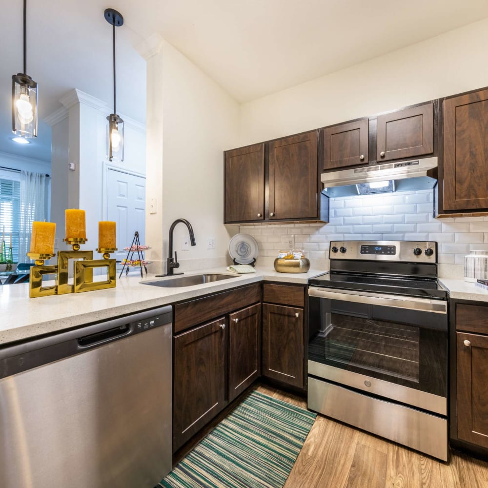 a kitchen with stainless steel appliances and wood cabinets at The Pines on Spring Rain