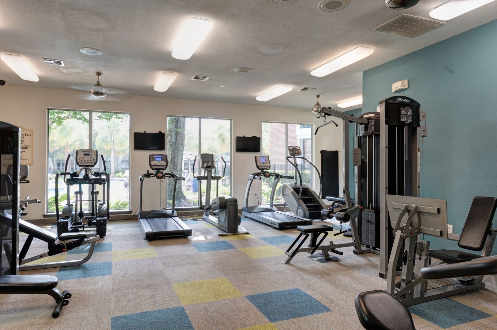 a gym room with exercise equipment and windows at The Boulevard at Deer Park