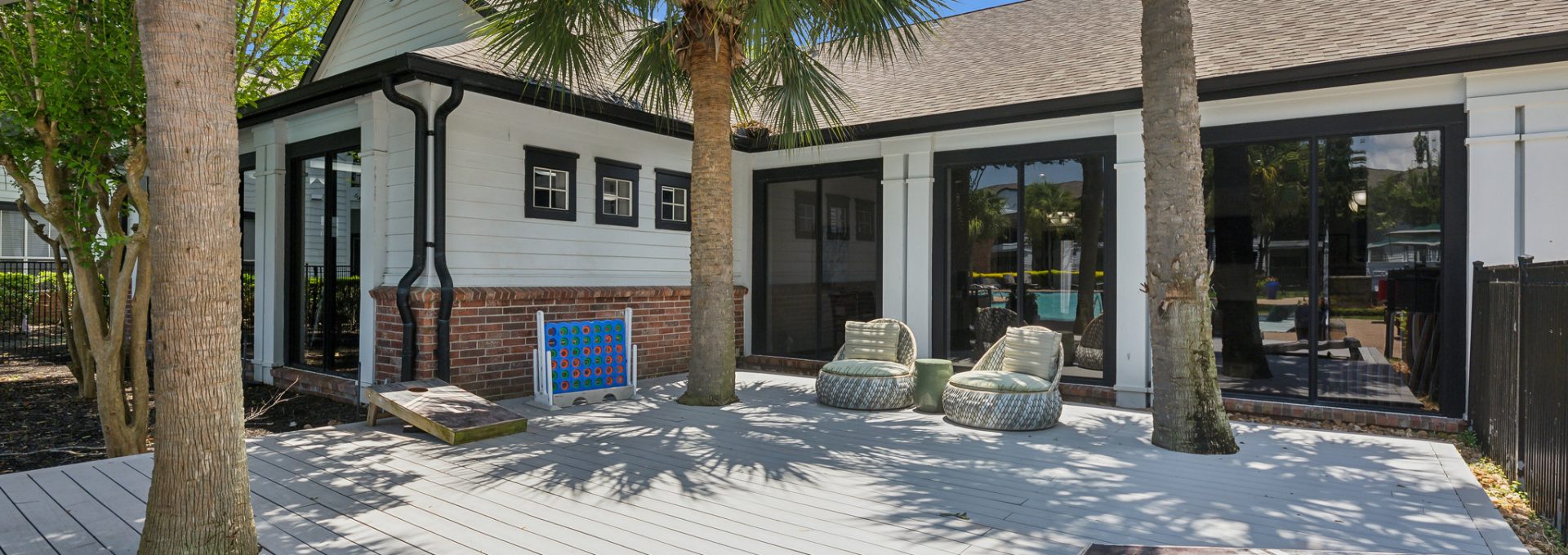 a deck with palm trees and a white fence at The  Boulevard at Deer Park