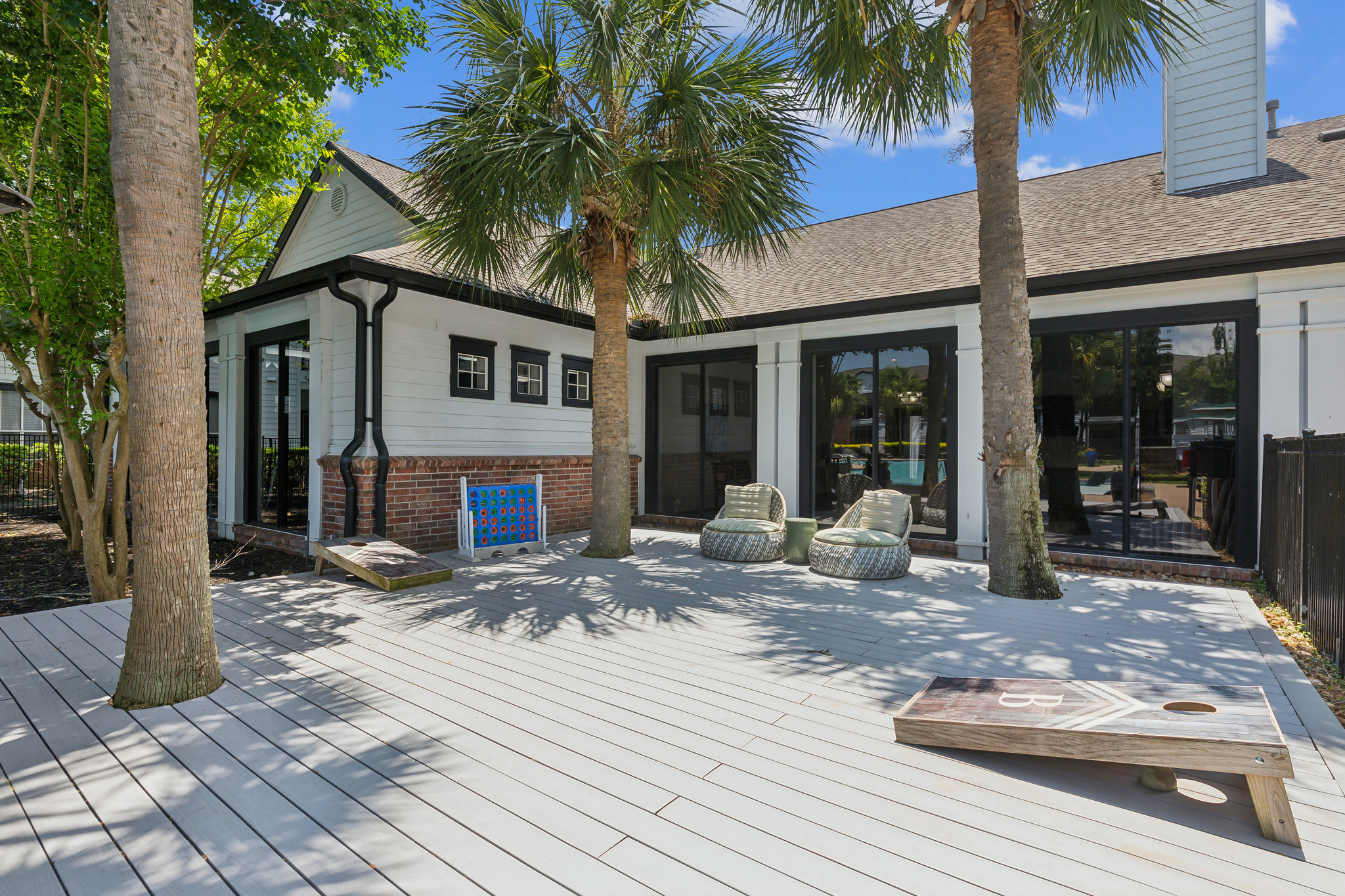 a deck with palm trees and a white fence at The  Boulevard at Deer Park