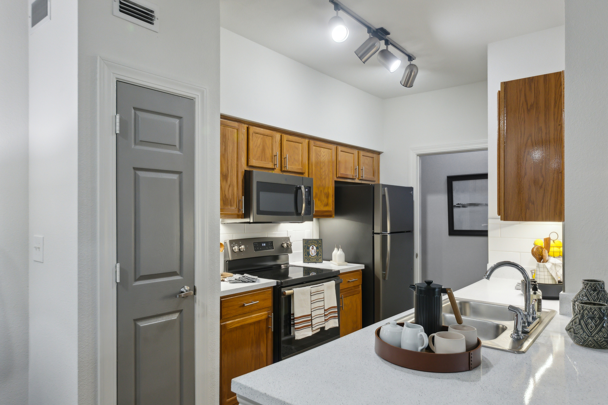 a kitchen with a refrigerator, microwave and sink at The  Boulevard at Deer Park