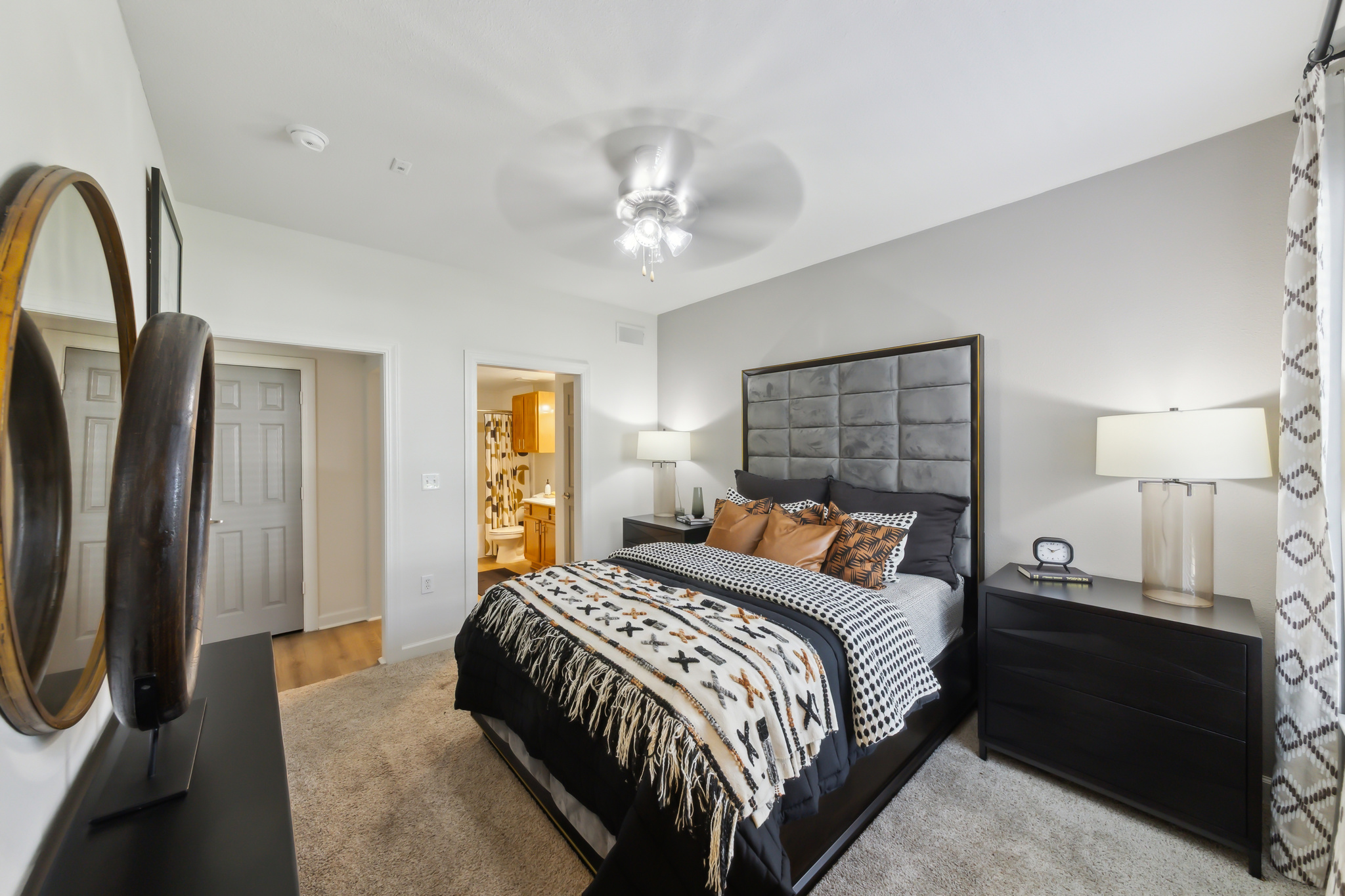 a bedroom with a bed, dresser and mirror at The  Boulevard at Deer Park