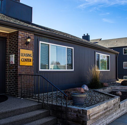 the exterior of a building with a sign that says, welcome to the neighborhood at The Windchase Flats and Townhomes