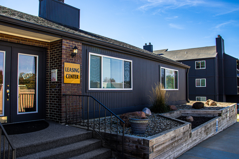the exterior of a building with a sign that says, welcome to the neighborhood at The Windchase Flats and Townhomes
