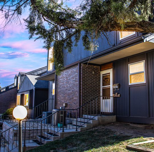 a house with a front porch and stairs at The Windchase Flats and Townhomes