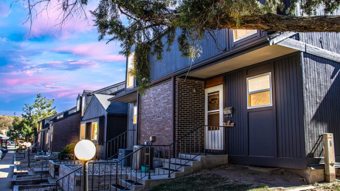 a house with a front porch and stairs at The Windchase Flats and Townhomes