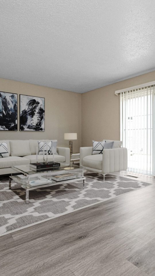 a living room with hardwood floors and a large window at The Windchase Flats and Townhomes