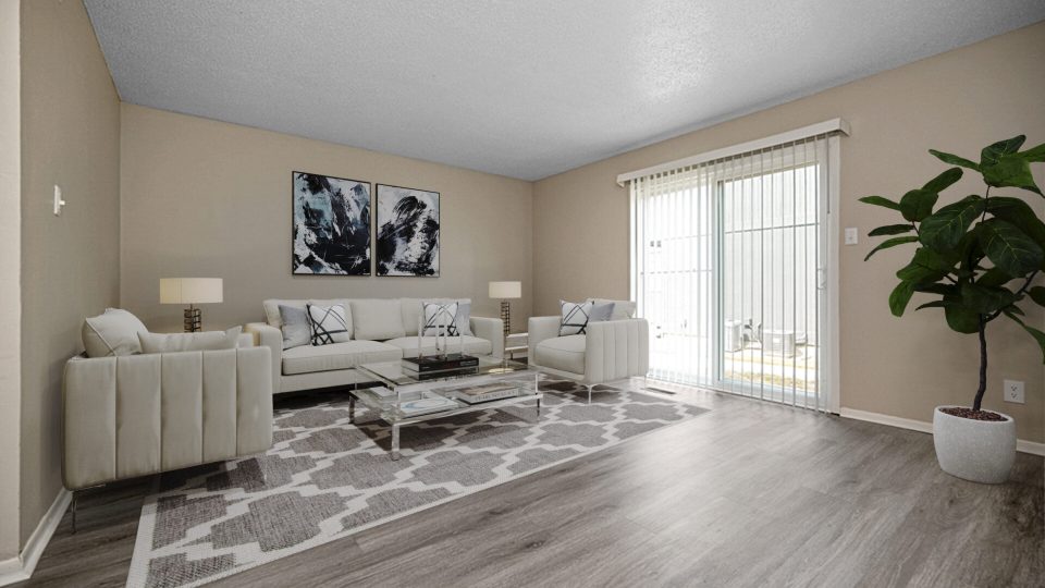 a living room with hardwood floors and a large window at The Windchase Flats and Townhomes