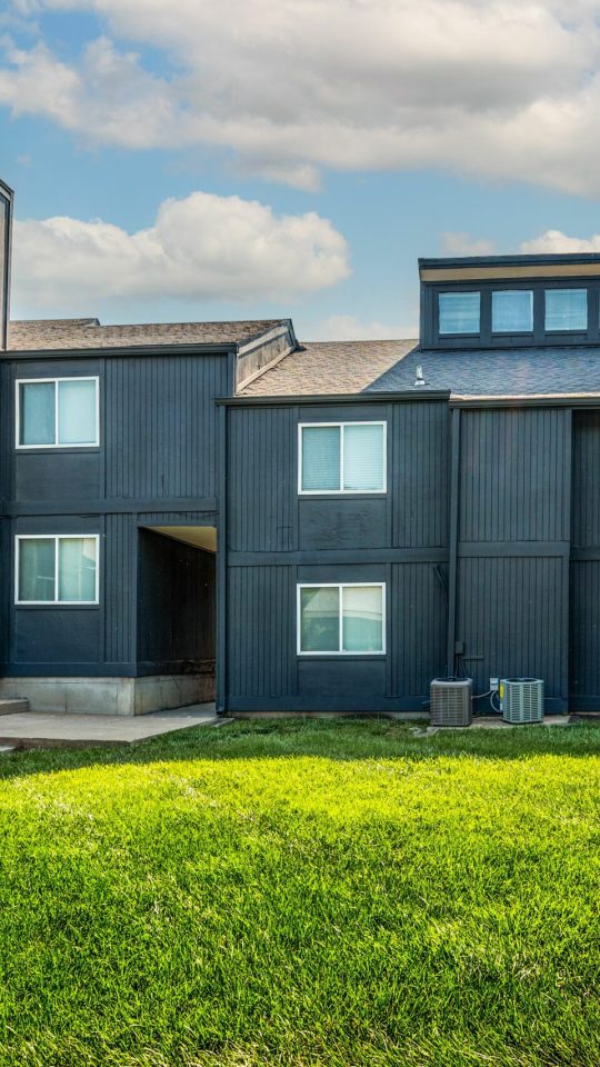 the exterior of an apartment complex with orange and black trim at The Windchase Flats and Townhomes