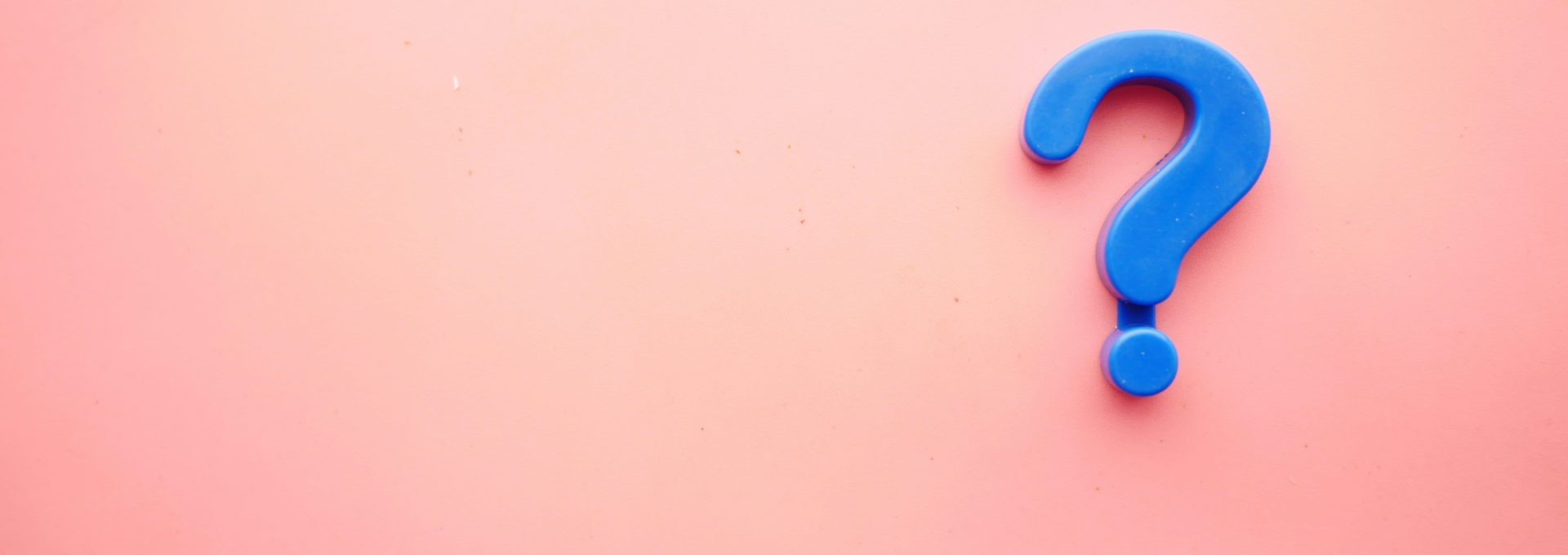 a blue question mark on a pink background
