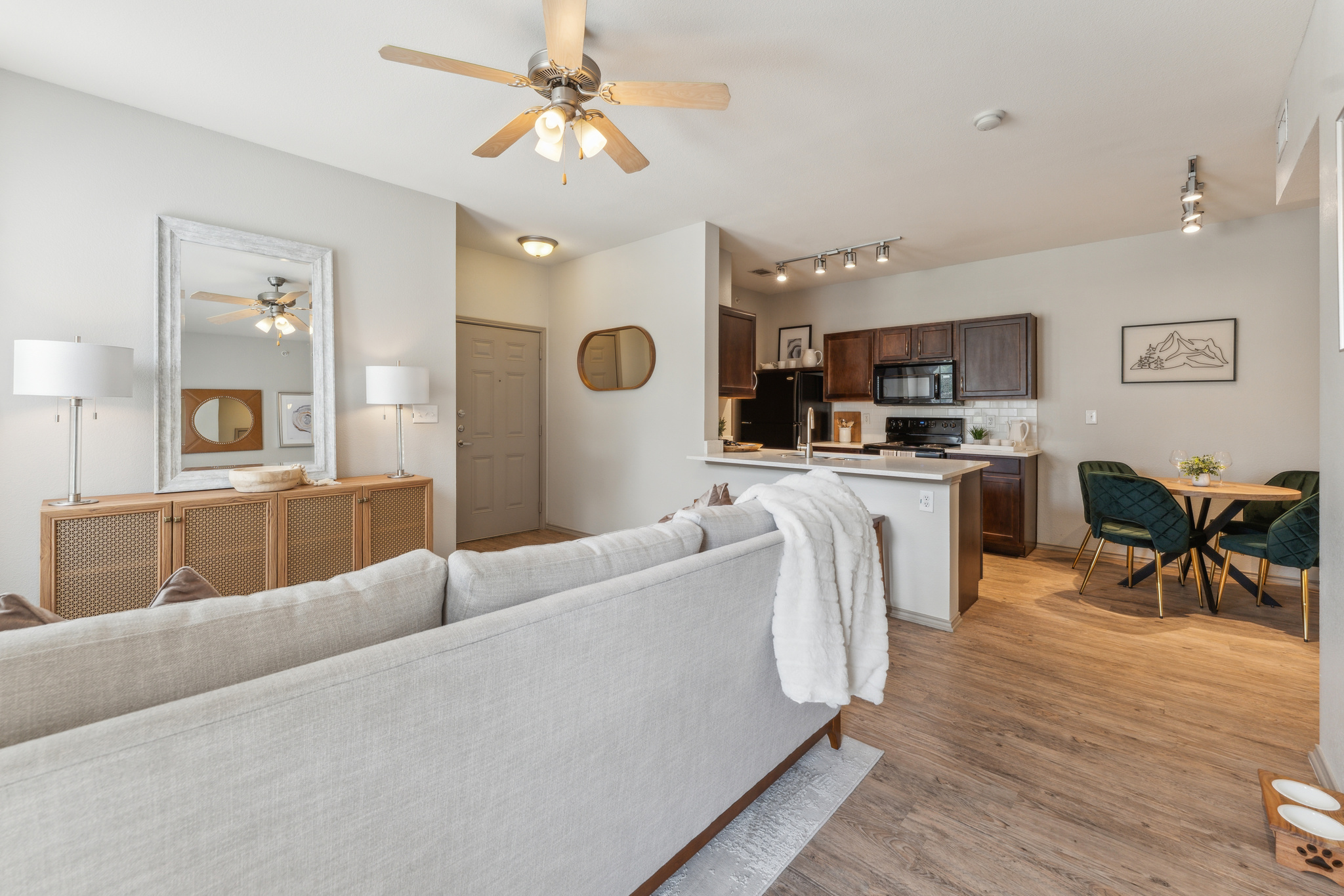 a living room and kitchen area with a ceiling fan at The  Wyatt at Presidio Junction