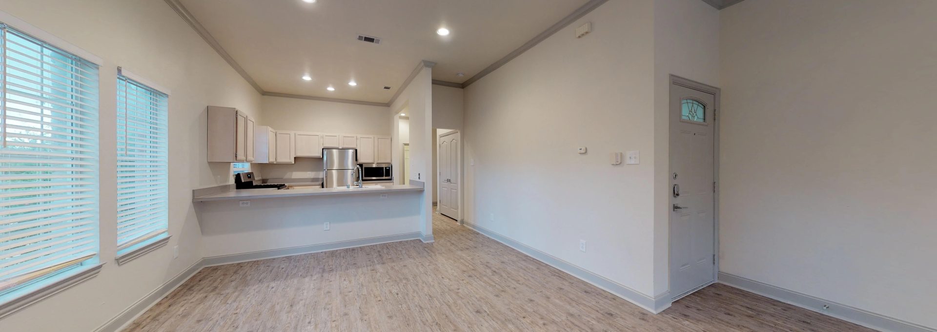 an empty room with hardwood floors and a kitchen at The Franconia Court