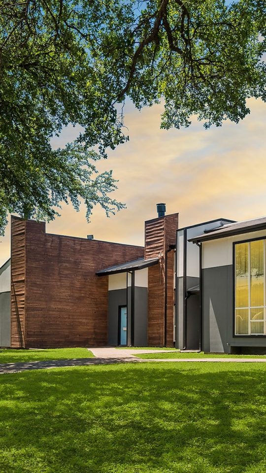 a house with a green lawn and trees at The Southwind