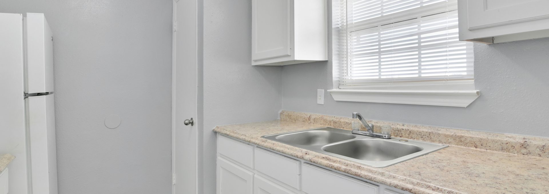 a kitchen with white cabinets and granite counter tops at The Southwind