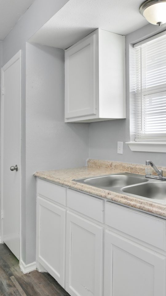 a kitchen with white cabinets and granite counter tops at The Southwind
