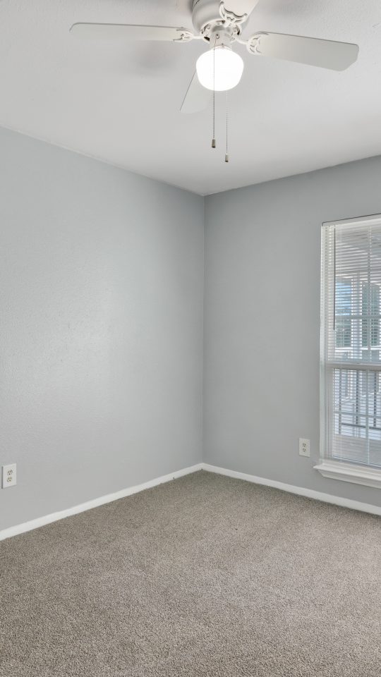 empty room with ceiling fan and carpet at The Southwind