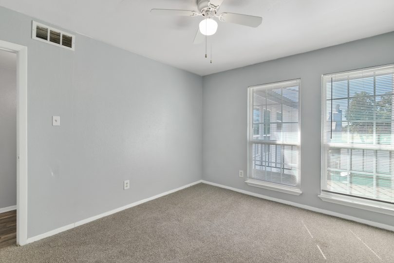 empty room with ceiling fan and carpet at The Southwind